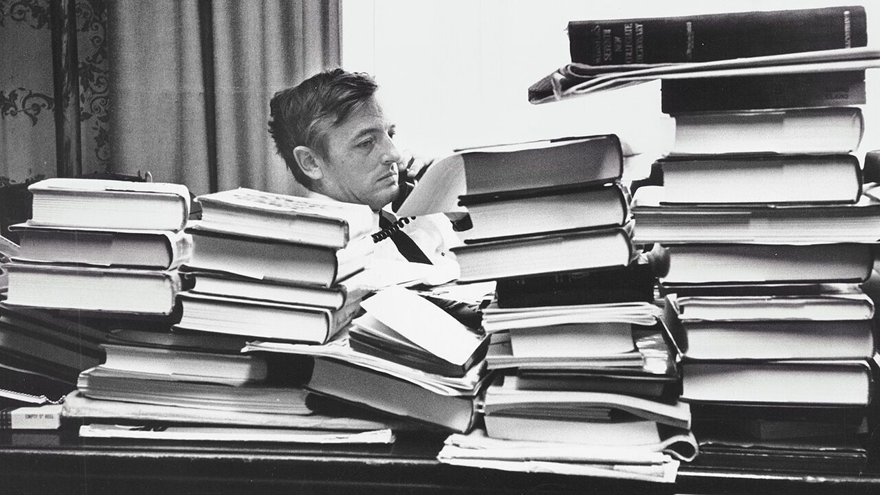 William Buckley in his office surrounded by piles of books